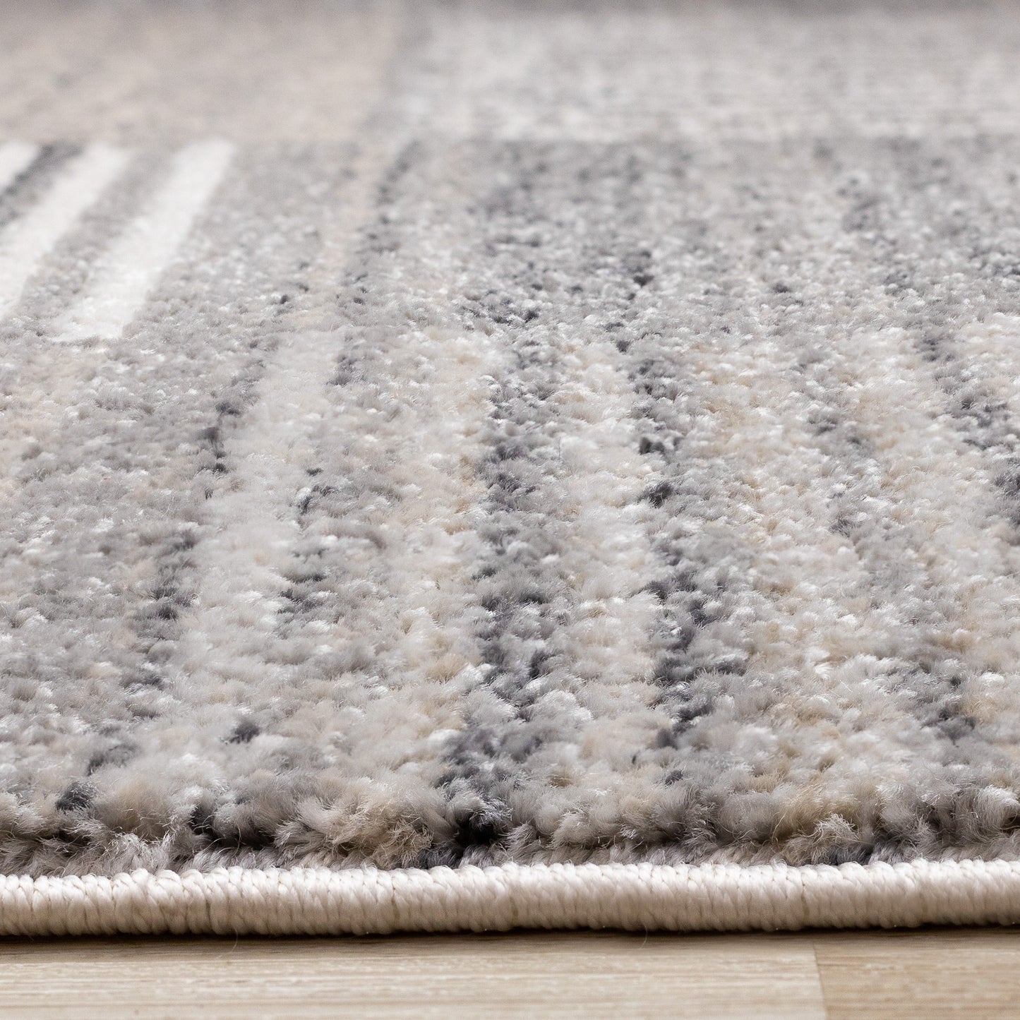 Alfombra contemporánea gris con diseño geométrico desgastado