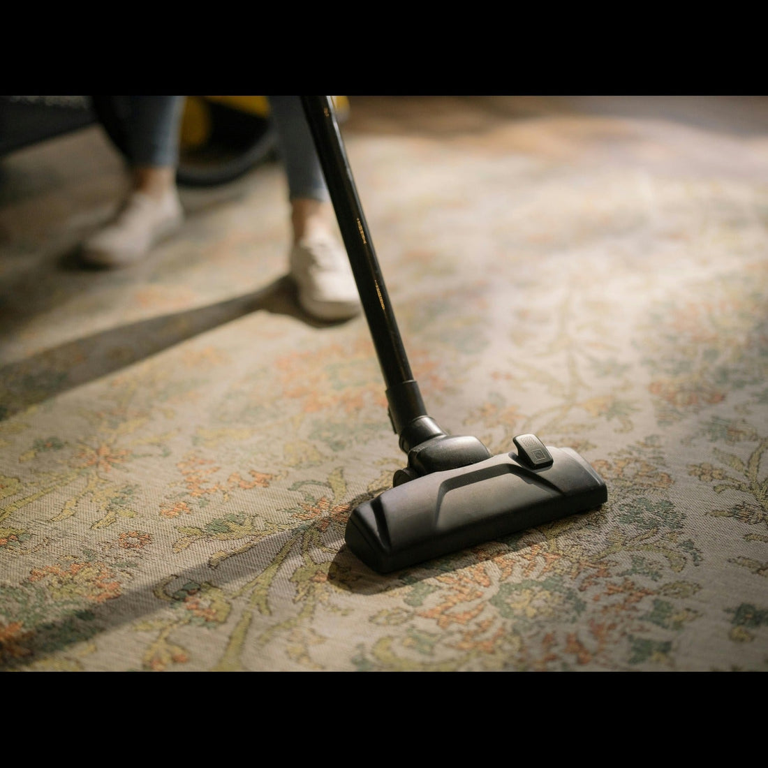 rug is being cleaned with vacuum cleaner