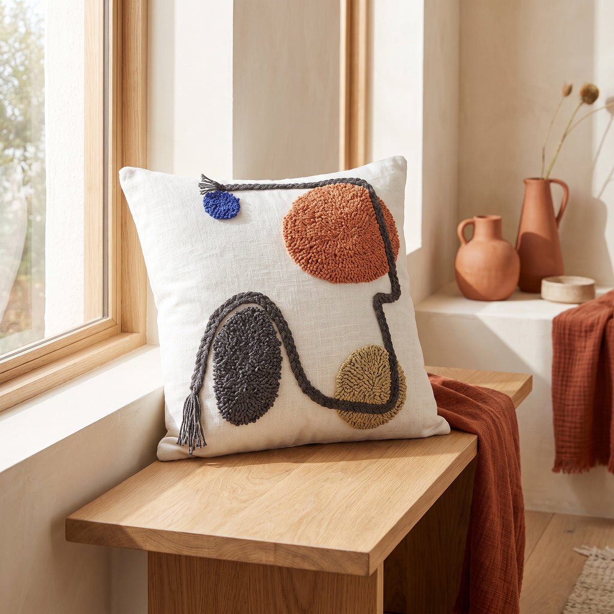 Rhea Tufted White and Rust Pillow in a room